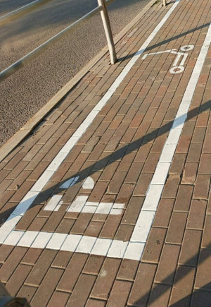 Разметка выглядит как прямоугольник и в границах этой зоны нужно оставить самокат.