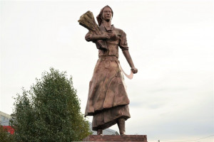 Центральный образ – женщина с серпом в одной руке и снопом пшеницы в другой – олицетворяет стойкость, самоотверженность и несгибаемую силу духа сельских тружеников.