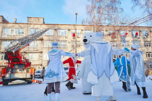 В костюмах Дедов Морозов они спустились на страховочных тросах с крыши медучреждения, заглянув в каждое окно. Внизу детей приветствовали Снегурочка и символ Севера — Белый Медведь.